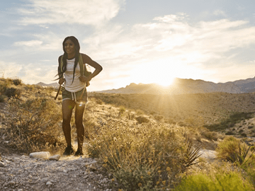 Hiker on desert trail at sunrise