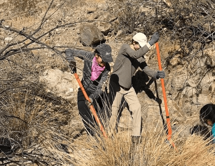 People digging in dry, rocky terrain